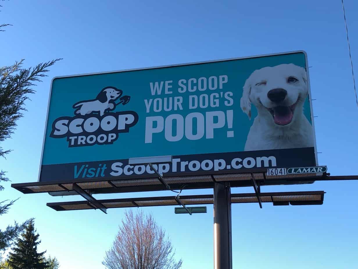 A bill board of scoop troop with a winking dog