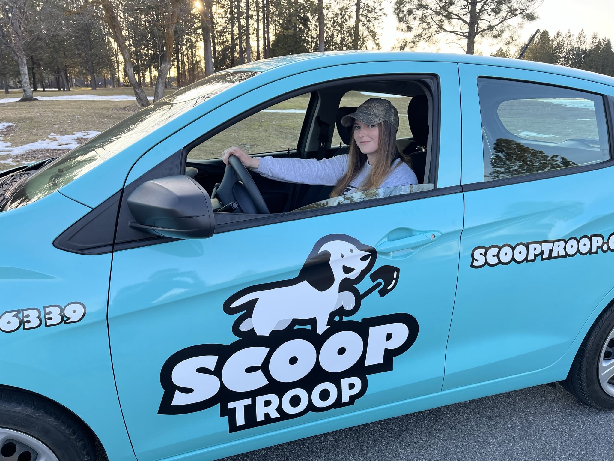 Scoop Troop dog waste removal car being driven by a female employee